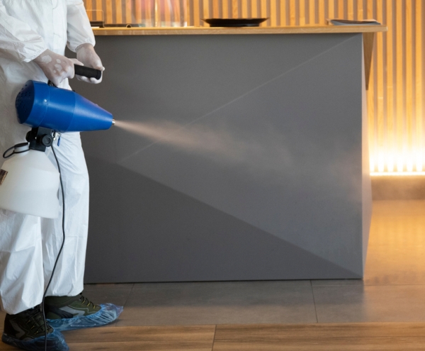 Man in white spraying cleaning solution