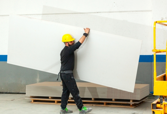 skip hire - plasterboard being carried by a worker