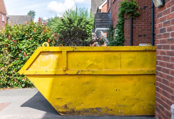 Yellow skip in a driveway