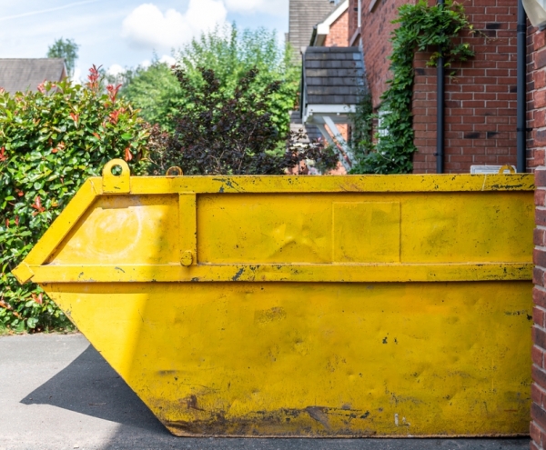 Yellow skip in a driveway